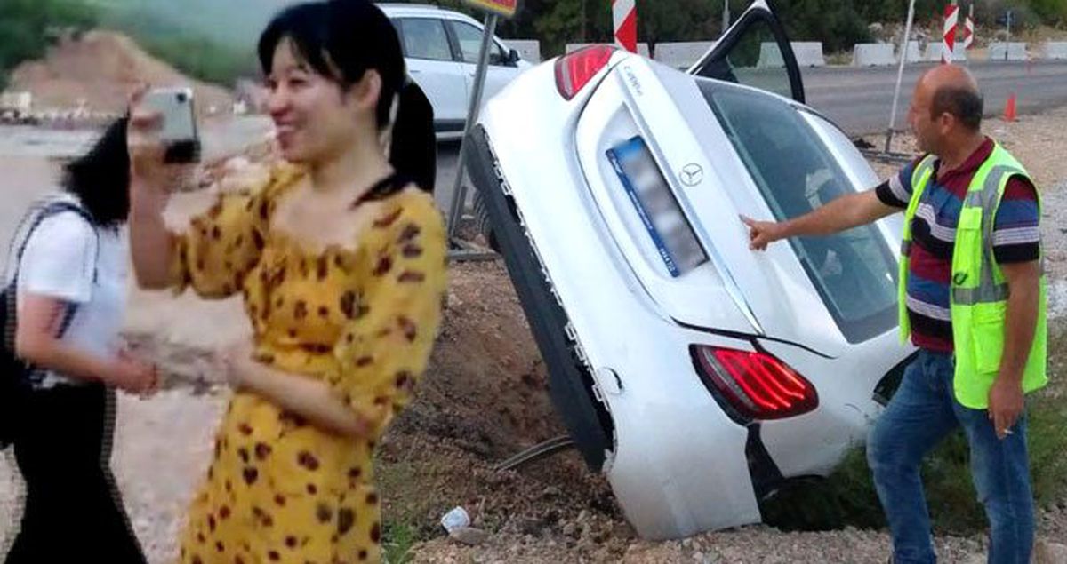 Kaza yapan turistler, aracın başında gülümseyerek poz verdi