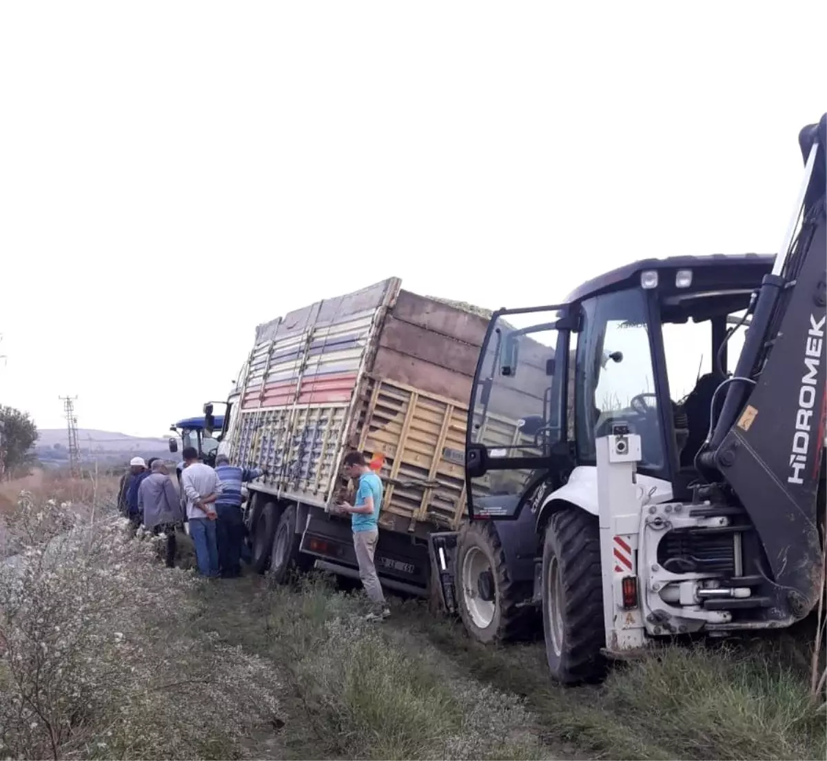 Çamura saplanan kamyonu kepçe kurtardı