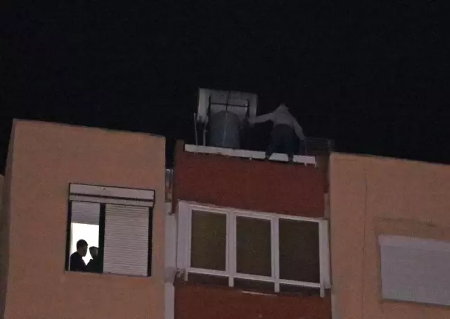 12 katlı apartmanın çatısından aşağı sarkan genç kadını film izler gibi izlediler 12 katlı apartmanın çatısından aşağı sarkan genç kadını film izler gibi izlediler