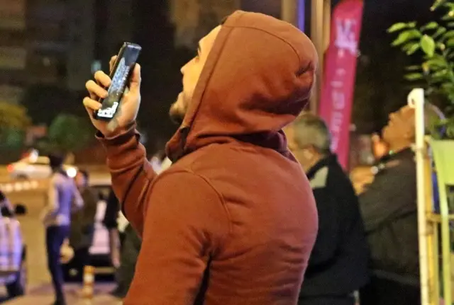 12 katlı apartmanın çatısından aşağı sarkan genç kadını film izler gibi izlediler 12 katlı apartmanın çatısından aşağı sarkan genç kadını film izler gibi izlediler