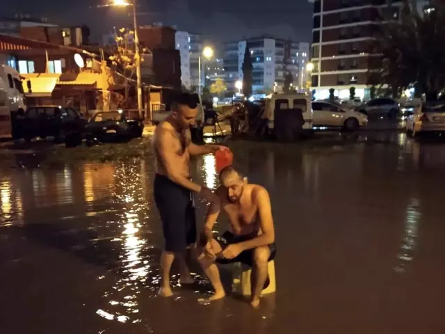 İzmir'de su kesintisine dikkati çekmek için yağmur suyuyla sokakta yıkandılar İzmir'de su kesintisine dikkati çekmek için yağmur suyuyla sokakta yıkandılar