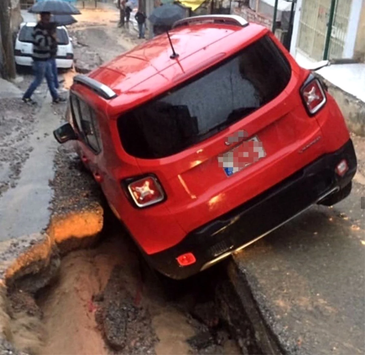 İzmir'de araçlar sağanak yağmurda oluşan çukura düştü