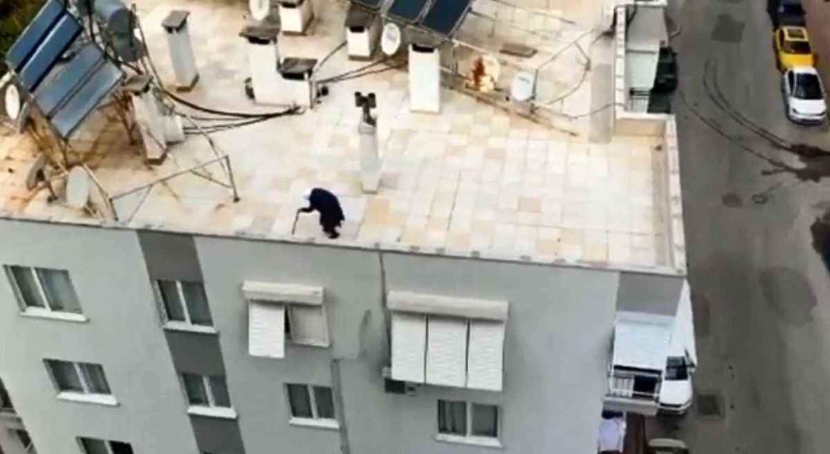 Koronavirüs tedbirleri kapsamında dışarı çıkması yasaklanan yaşlı teyze, çatıda bastonuyla volta attı