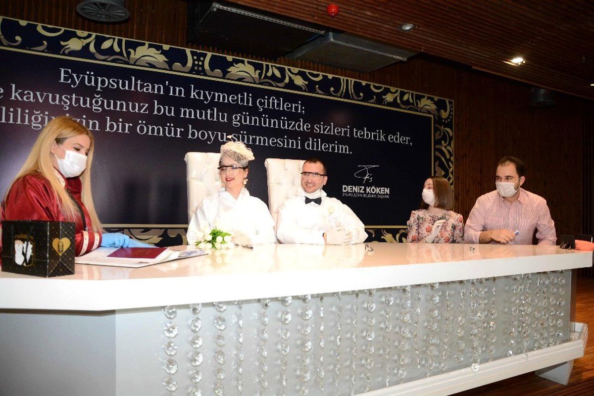 Koronavirüse karşı koyan çift, tulum giyip maske ve eldiven takarak evlendi
