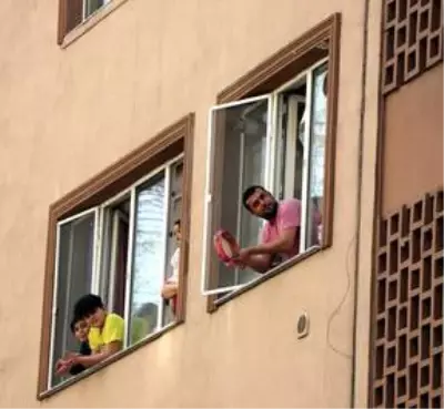 Evinin penceresinden çaldığı tulumla komşularına moral veriyor Evinin penceresinden çaldığı tulumla komşularına moral veriyor