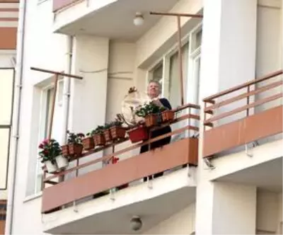 Evinin penceresinden çaldığı tulumla komşularına moral veriyor Evinin penceresinden çaldığı tulumla komşularına moral veriyor