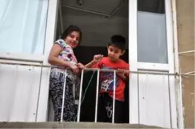 Sokağa çıkamayan çocuklar şekerlerini sepet sarkıtarak aldı Sokağa çıkamayan çocuklar şekerlerini sepet sarkıtarak aldı