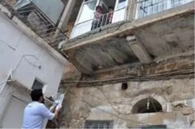 Sokağa çıkamayan çocuklar şekerlerini sepet sarkıtarak aldı