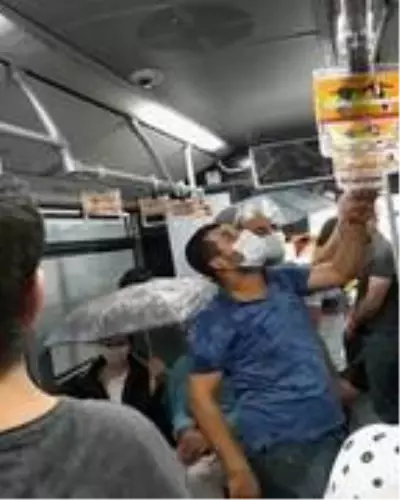 Metrobüs içinde tavandan akan sudan şemsiyeyle korundular Metrobüs içinde tavandan akan sudan şemsiyeyle korundular