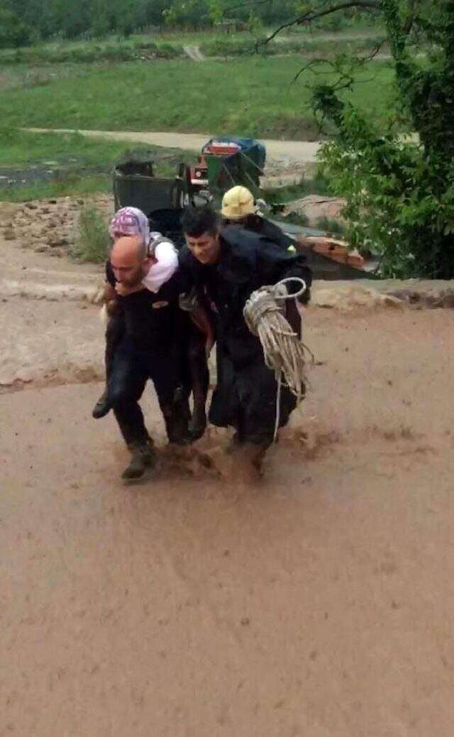 İtfaiyeci, selin ortasında köpeğiyle mahsur kalan kadını sırtında taşıdı