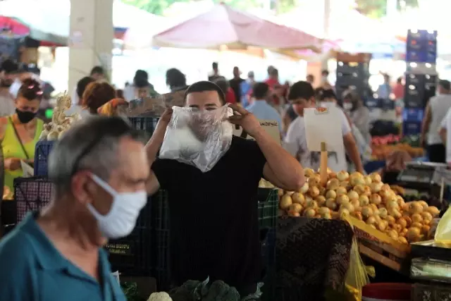 Görüntülendiğini anlayan maskesiz esnaf poşeti maskeye çevirdi