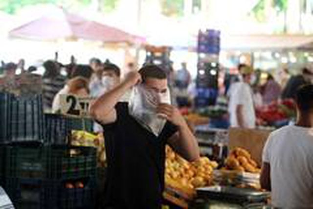 Görüntülendiğini anlayan maskesiz esnaf poşeti maskeye çevirdi