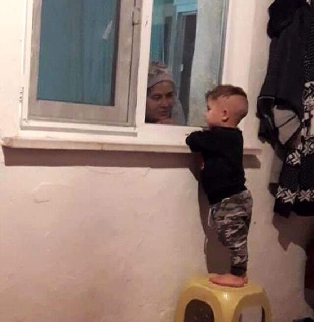 Koronanın acı tablosu; karantinadaki babaannesiyle cam arkasından oynuyor Koronanın acı tablosu; karantinadaki babaannesiyle cam arkasından oynuyor
