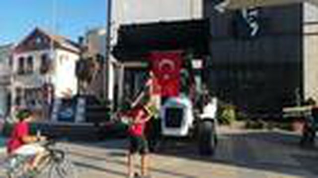 Arkadaşının omzuna çıkıp, iş makinesinde asılı bayrağı düzeltti