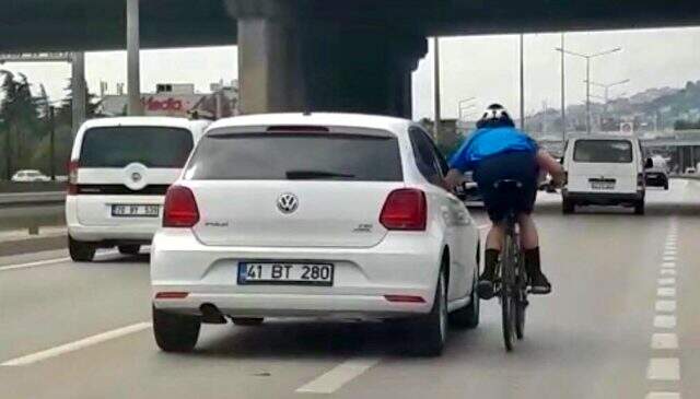 Otomobile tutunarak ilerleyen bisikletli ölüme meydan okudu