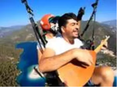 Yamaç paraşütünde bağlama çalıp, Neşet Ertaş türküsü söyledi Yamaç paraşütünde bağlama çalıp, Neşet Ertaş türküsü söyledi