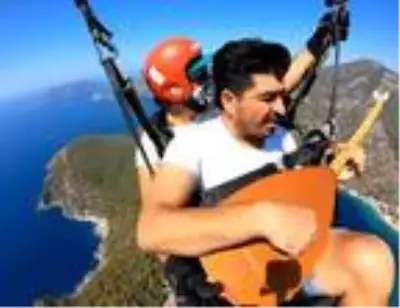 Yamaç paraşütünde bağlama çalıp, Neşet Ertaş türküsü söyledi Yamaç paraşütünde bağlama çalıp, Neşet Ertaş türküsü söyledi