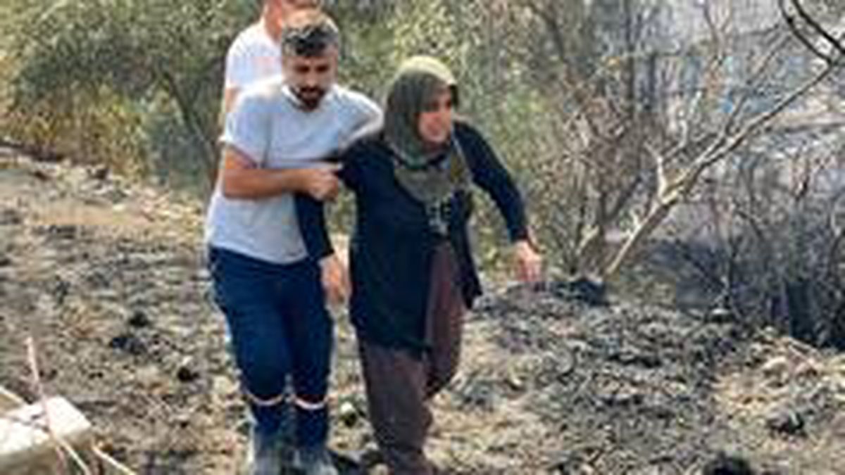 Hatay'da yanan evine koşmaya çalışan kadın güçlükle ikna edildi