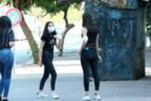 Maskesi kolunda olan genç kız, denetimdeki polisleri görünce yolunu değiştirdi