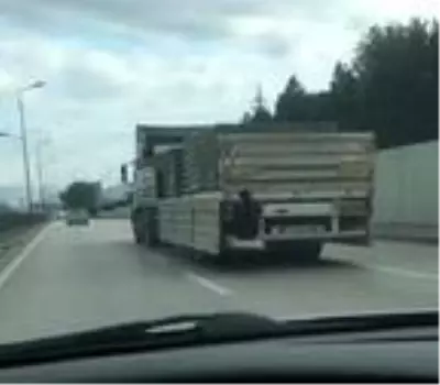 Kamyon kasasına tutunan gencin tehlikeli yolculuğu kamerada Kamyon kasasına tutunan gencin tehlikeli yolculuğu kamerada
