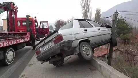 Telefon direğine çarpan otomobil 5 metre yüksekliğindeki istinat duvarının kenarında kaldı Telefon direğine çarpan otomobil 5 metre yüksekliğindeki istinat duvarının kenarında kaldı