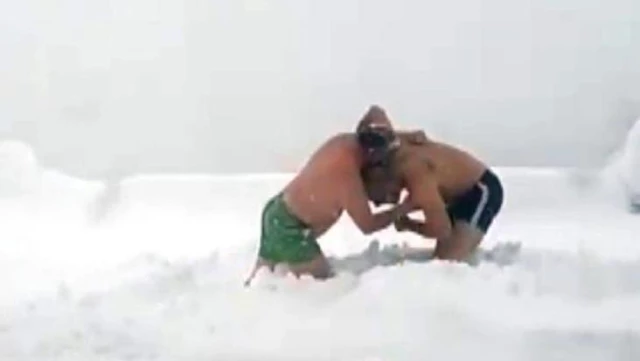 Soğuk havaya aldırış etmeyen iki kafadar, karın keyfini güreş tutarak çıkardı