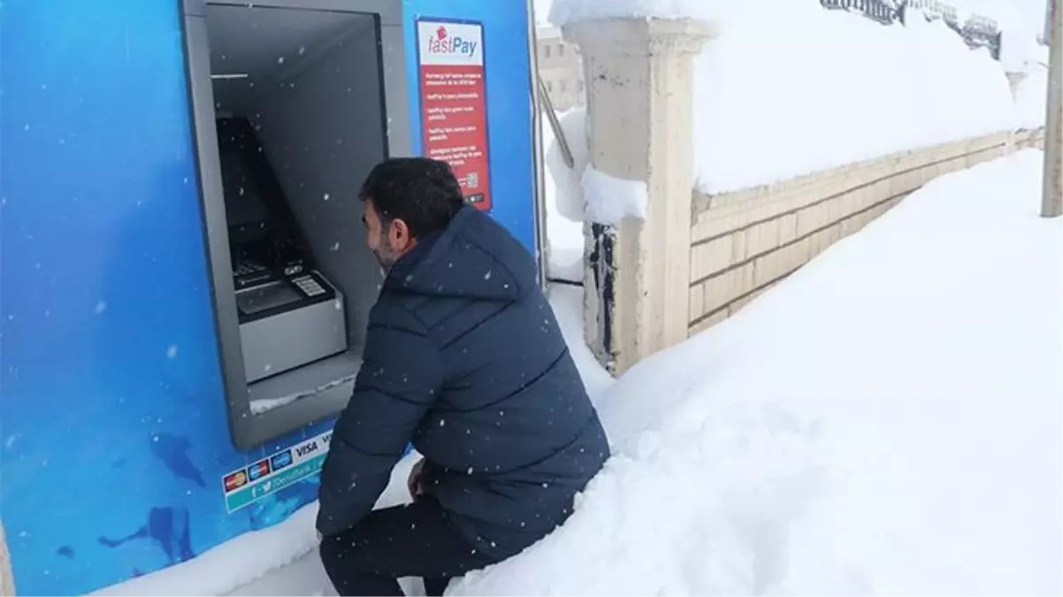 ATM'lerden paralarını, boyu iki buçuk metreyi aşan karın üstüne oturarak çekiyorlar