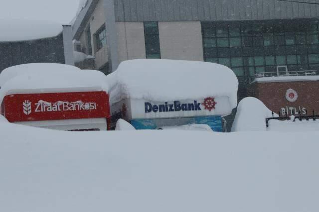 ATM'lerden paralarını boyu iki buçuk metreyi aşan karın üstüne oturarak çekiyorlar