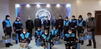 Kürek ve süpürgelerini bırakıp, bayrak törenine eşlik eden işçilere hediye