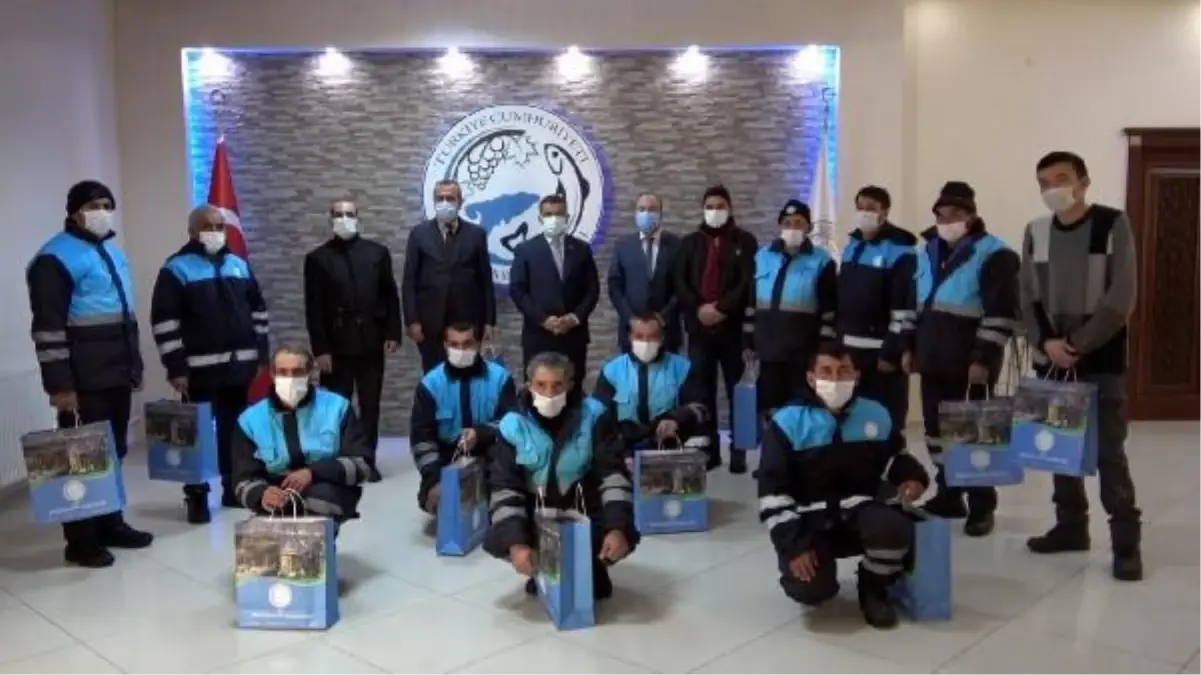 Kürek ve süpürgelerini bırakıp, bayrak törenine eşlik eden işçilere hediye