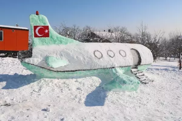 Bahçesinde 5 metre uzunluğunda kardan uçak yaptı Bahçesinde 5 metre uzunluğunda kardan uçak yaptı