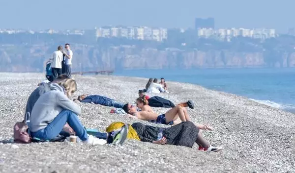 Kısıtlamada turistlerin sahilde güneş keyfi Kısıtlamada turistlerin sahilde güneş keyfi