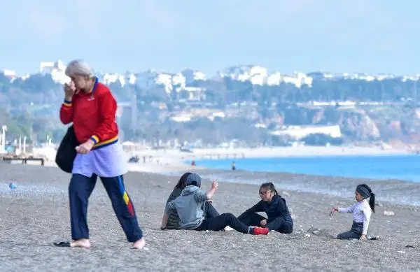 Kısıtlamada turistlerin sahilde güneş keyfi Kısıtlamada turistlerin sahilde güneş keyfi