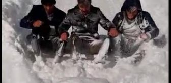 Kamyonete bağlı tahtalı düzeneğe oturan grup, kar küreyip kaydı