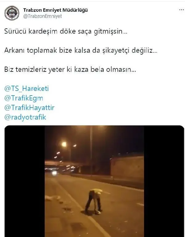 Elindeki kartonla yoldaki atıkları süpüren polise övgü Elindeki kartonla yoldaki atıkları süpüren polise övgü