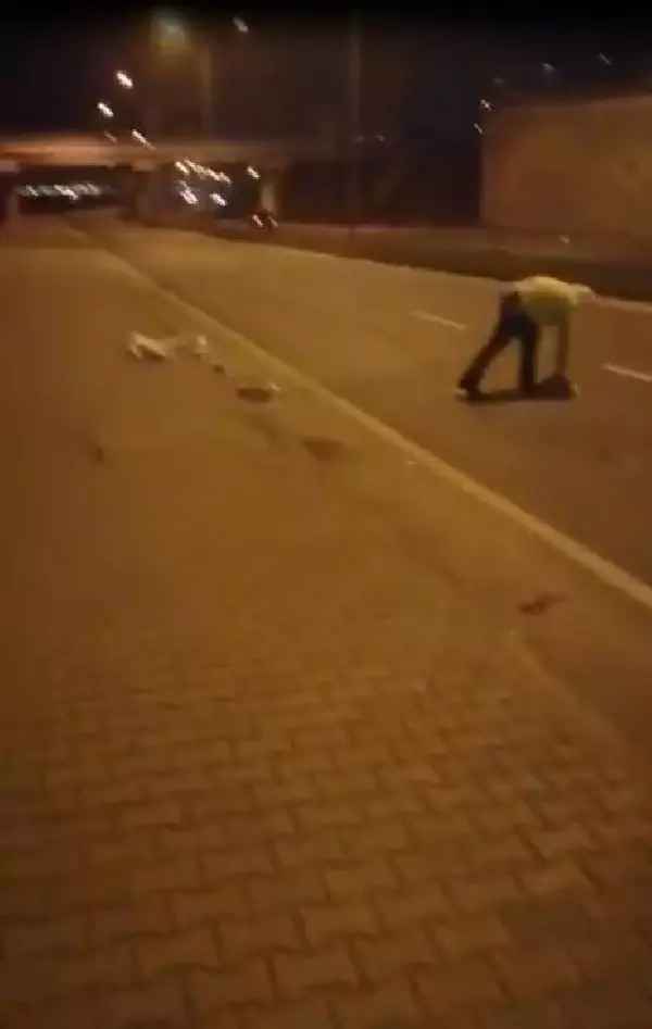 Elindeki kartonla yoldaki atıkları süpüren polise övgü Elindeki kartonla yoldaki atıkları süpüren polise övgü