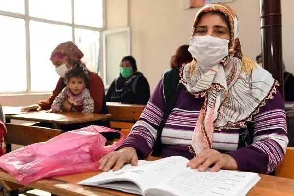 Kucaklarında çocukları ile okuma yazma öğreniyorlar Kucaklarında çocukları ile okuma yazma öğreniyorlar