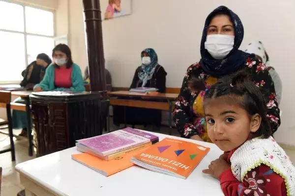 Kucaklarında çocukları ile okuma yazma öğreniyorlar Kucaklarında çocukları ile okuma yazma öğreniyorlar