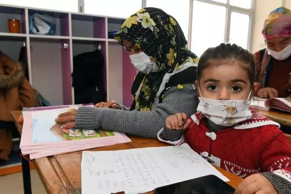 Kucaklarında çocukları ile okuma yazma öğreniyorlar Kucaklarında çocukları ile okuma yazma öğreniyorlar