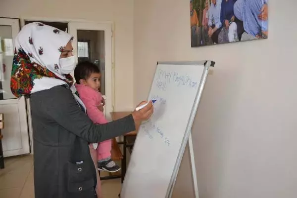 Kucaklarında çocukları ile okuma yazma öğreniyorlar Kucaklarında çocukları ile okuma yazma öğreniyorlar