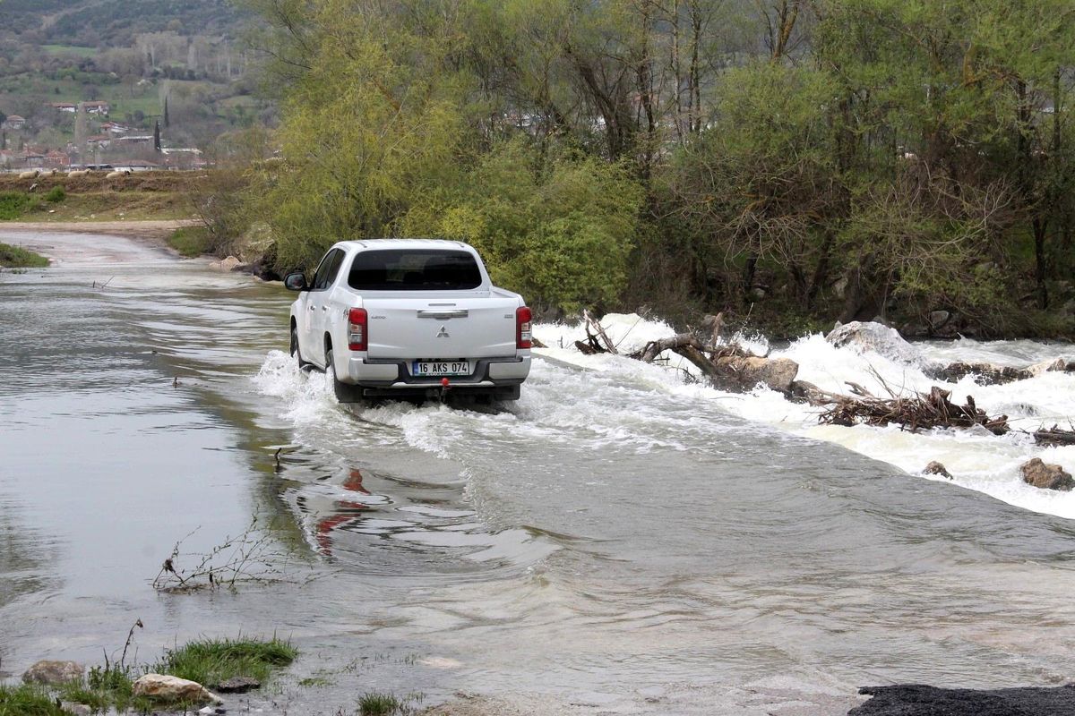 Su altında kalan köprüden tehlikeli geçiş