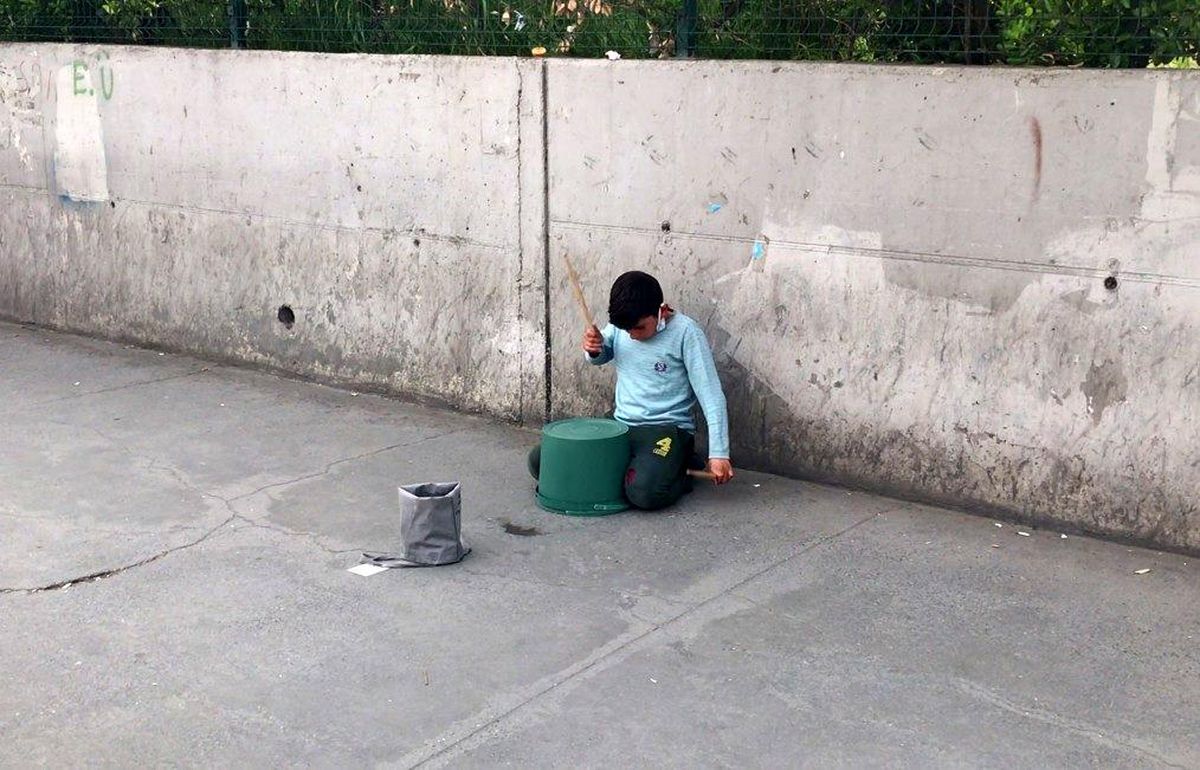 Kaldırımda oturan çocuğun kovayla yaptığı şov, yoldan geçenleri kendine hayran bıraktı