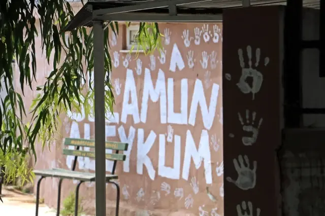 Boya kovasına ellerini batırıp caminin duvarlarını el izleriyle doldurdu Boya kovasına ellerini batırıp caminin duvarlarını el izleriyle doldurdu