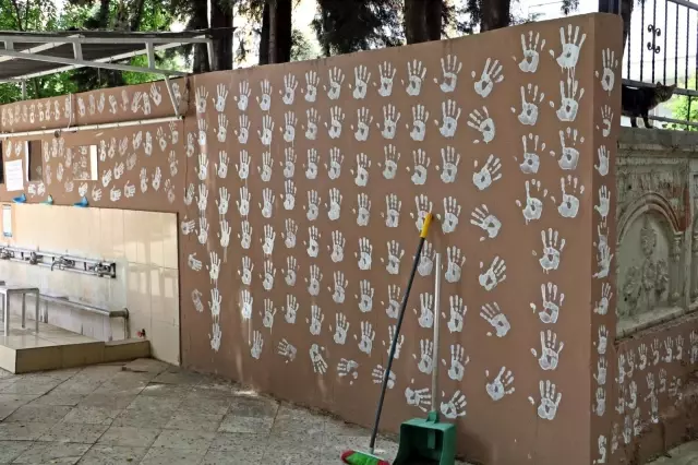 Boya kovasına ellerini batırıp caminin duvarlarını el izleriyle doldurdu Boya kovasına ellerini batırıp caminin duvarlarını el izleriyle doldurdu