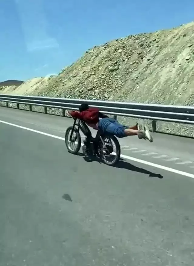 Motosikletin üstüne yatan sürücünün tehlikeli yolculuğu kamerada Motosikletin üstüne yatan sürücünün tehlikeli yolculuğu kamerada