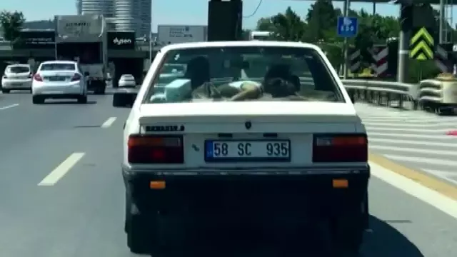 Küçük kız çocuğunu arabanın arka camına yatırdı Küçük kız çocuğunu arabanın arka camına yatırdı