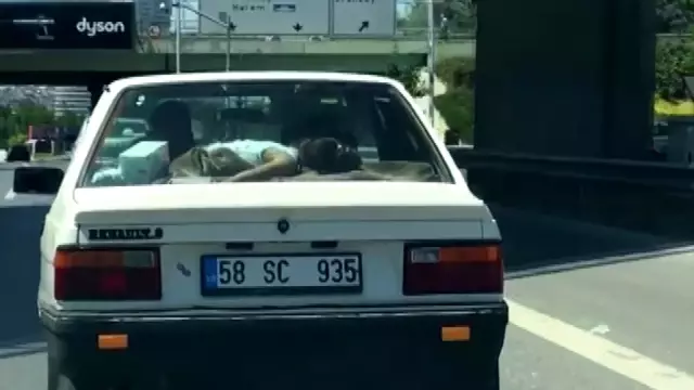 Küçük kız çocuğunu arabanın arka camına yatırdı Küçük kız çocuğunu arabanın arka camına yatırdı