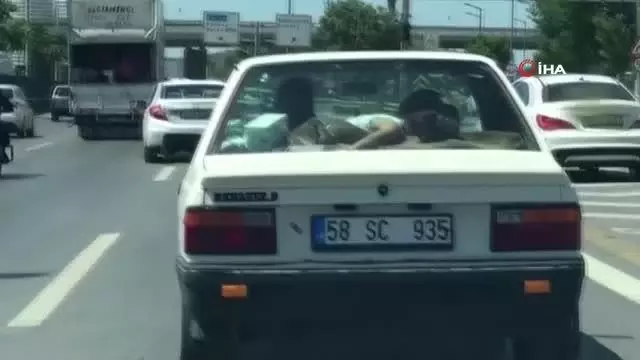 Trafikte ilginç görüntü: Uyuyan çocuğu arabanın arka camına yatırdı Trafikte ilginç görüntü: Uyuyan çocuğu arabanın arka camına yatırdı