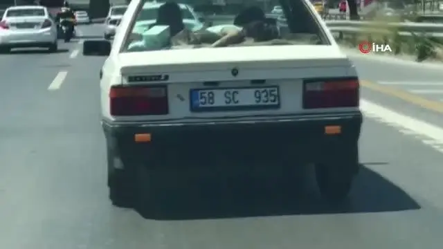 Trafikte ilginç görüntü: Uyuyan çocuğu arabanın arka camına yatırdı Trafikte ilginç görüntü: Uyuyan çocuğu arabanın arka camına yatırdı