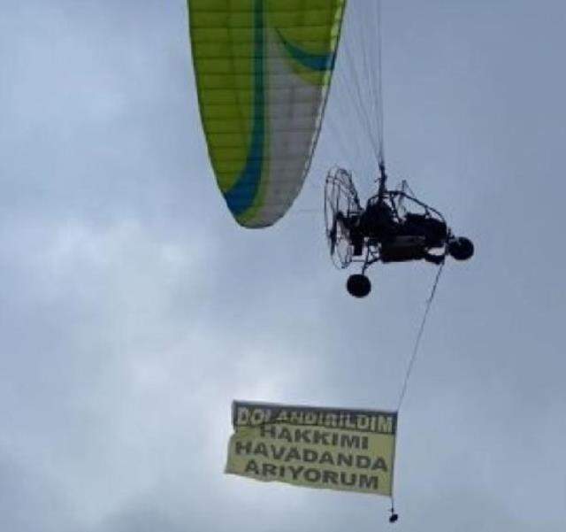 Savcılığın takipsizlik kararı sonrası kiraladığı paramotorla 'Dolandırıldım, hakkımı arıyorum' yazılı afişle uçtu